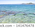 A clear, beautiful sea on a sunny day, with distant mountain ranges in the background. 141476478