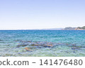 A coastal landscape with a clear blue sea and sky stretching out before you. 141476480