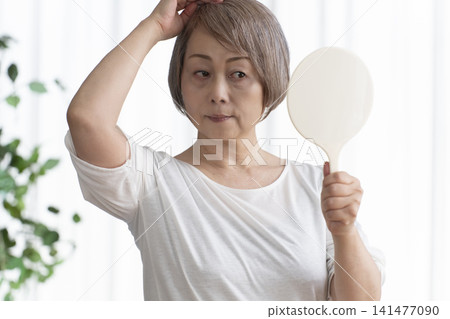 Senior woman with hand mirror Senior woman with hand mirror 141477090