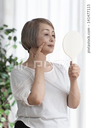 Senior woman with hand mirror Senior woman with hand mirror 141477115