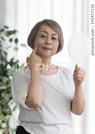 Senior woman with hand mirror Senior woman with hand mirror 141477116