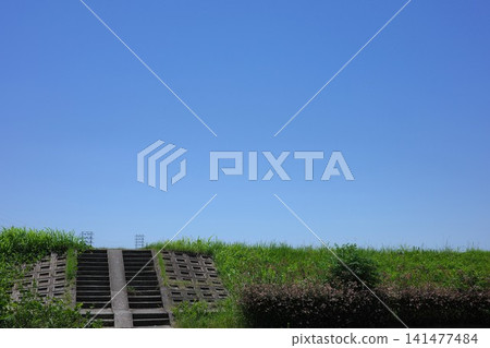 Blue sky and concrete steps leading to the riverbank 141477484