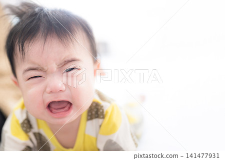 A Japanese baby crawling and crying; an image of a toddler going through the "terrible twos," night crying, parenting, and childcare. A Japanese baby crawling and crying; an image of a toddler going through the "terrible twos," night crying, parenting, and childcare. 141477931