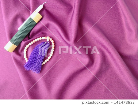 A backdrop that enhances prayer: candles, incense, and prayer beads. 141478652