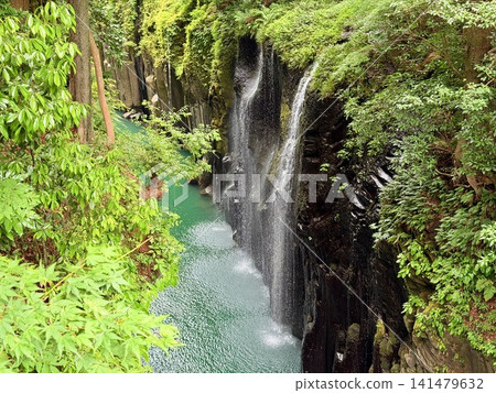 The Manai Falls and the magnificent columnar jointed gorge scenery can be seen in Takachiho Gorge in Takachiho Town, Miyazaki Prefecture. The Manai Falls and the magnificent columnar jointed gorge scenery can be seen in Takachiho Gorge in Takachiho Town, Miyazaki Prefecture. 141479632