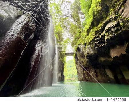 The Manai Falls and the magnificent columnar jointed gorge scenery can be seen in Takachiho Gorge in Takachiho Town, Miyazaki Prefecture. The Manai Falls and the magnificent columnar jointed gorge scenery can be seen in Takachiho Gorge in Takachiho Town, Miyazaki Prefecture. 141479666