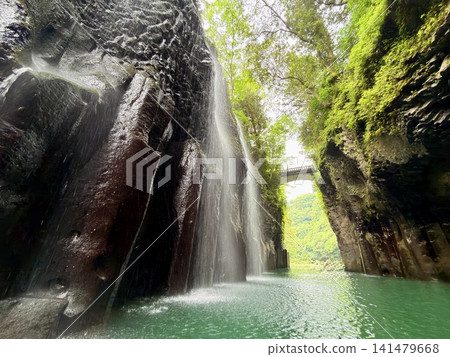 The Manai Falls and the magnificent columnar jointed gorge scenery can be seen in Takachiho Gorge in Takachiho Town, Miyazaki Prefecture. The Manai Falls and the magnificent columnar jointed gorge scenery can be seen in Takachiho Gorge in Takachiho Town, Miyazaki Prefecture. 141479668