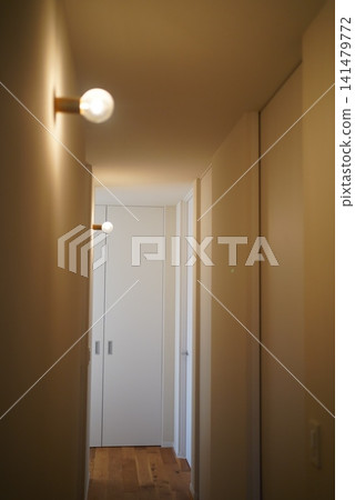 A bare light bulb pendant light and white storage shelves hanging from the ceiling. A bare light bulb pendant light and white storage shelves hanging from the ceiling. 141479772