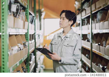 A man in work clothes managing inventory 141480011