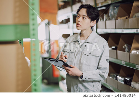 一名身穿工作服的男子正在清點庫存。 141480014