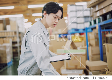 一名身穿工作服的男子正在清點庫存。 一名身穿工作服的男子正在清點庫存。 141480250