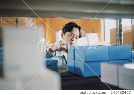 一名身穿工作服的男子正在清點庫存。 141480407