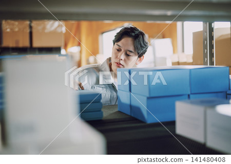 一名身穿工作服的男子正在清點庫存。 一名身穿工作服的男子正在清點庫存。 141480408