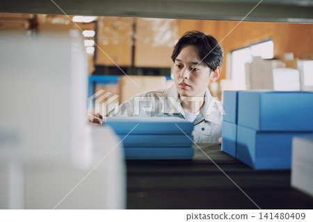 一名身穿工作服的男子正在清點庫存。 一名身穿工作服的男子正在清點庫存。 141480409