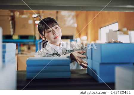 一名穿著工作服的女士在倉庫管理庫存 141480431