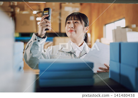 一名穿著工作服的女士在倉庫管理庫存 141480438