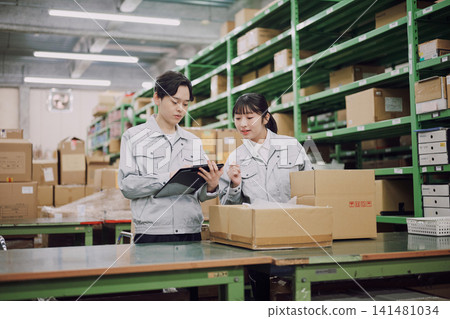 Young men and women working in a warehouse Young men and women working in a warehouse 141481034