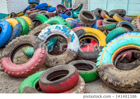 Pile of old multicolored car tires dug in playgrounds. Multicolor used tires. various sizes colored tires. 141481386