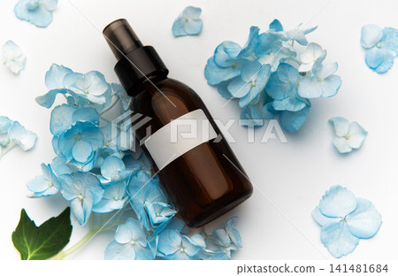 Cosmetic spray bottle with blue hydrangea petals Cosmetic spray bottle with blue hydrangea petals 141481684