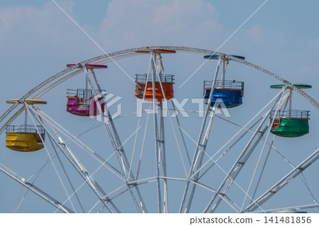 Colorful Ferris Wheel Cabins Against a Clear Blue Sky. Colorful Ferris Wheel Cabins Against a Clear Blue Sky. 141481856