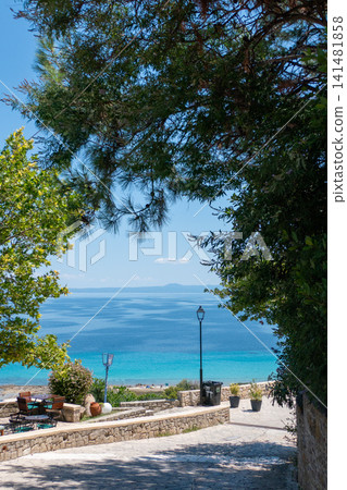 Scenic stone path viewpoint overlooking the turquoise sea in Afytos, Kassandra, Halkidiki, Greece Scenic stone path viewpoint overlooking the turquoise sea in Afytos, Kassandra, Halkidiki, Greece 141481858
