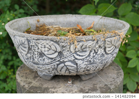Concrete garden planter with embossed leaf pattern in the garden Concrete garden planter with embossed leaf pattern in the garden 141482094
