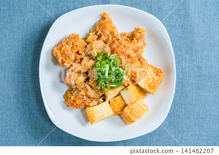 Chicken simmered in grated daikon radish sauce with deep-fried tofu - a Japanese-style side dish. Chicken simmered in grated daikon radish sauce with deep-fried tofu - a Japanese-style side dish. 141482207