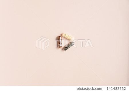 Superfood seeds inside clear capsules on beige background. Superfood seeds inside clear capsules on beige background. 141482332