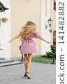 Carefree Woman Twirling With Flowing Hair In City Street 141482882