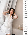 Cheerful Woman Relaxing Near Large Window Indoors 141482886