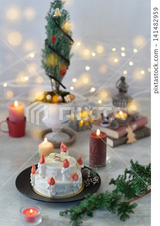 一個夢幻般的聖誕蛋糕展示櫃，裝飾著蠟燭燈光和聖誕樹。 141482959