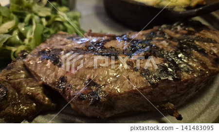 Grilled steak with greens on a dinner plate Grilled steak with greens on a dinner plate 141483095
