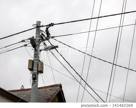 Utility pole with overhead power and communication lines Utility pole with overhead power and communication lines 141483169