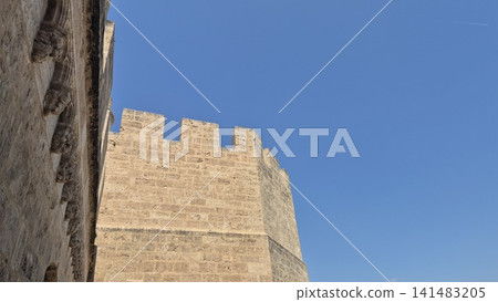 Ancient stone fortress wall against blue sky Ancient stone fortress wall against blue sky 141483205