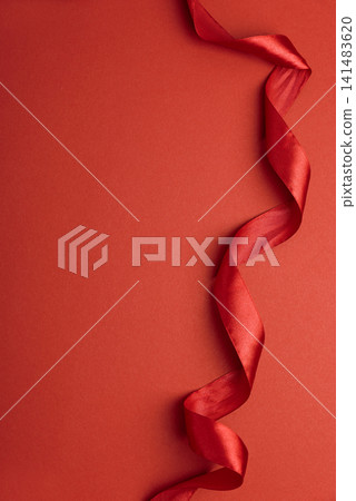 Red satin ribbon floating on red background for celebration Red satin ribbon floating on red background for celebration 141483620