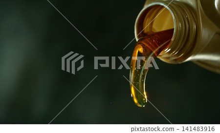 Pouring Fresh New Motor Oil into Car's Engine Pouring Fresh New Motor Oil into Car's Engine 141483916