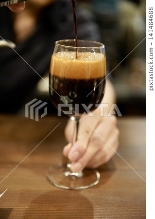 黑啤酒倒入酒杯中 141484688