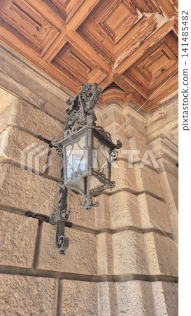 Ornate vintage wall lantern on stone facade 141485482