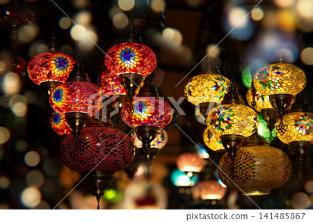 Colorful decorative lanterns illuminate a marketplace filled with vibrant patterns and warm light during an evening setting Colorful decorative lanterns illuminate a marketplace filled with vibrant patterns and warm light during an evening setting 141485867