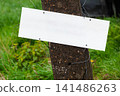 Blank White Signboard On Weathered Post In Rural Grass Field For Message Or Advertising 141486263