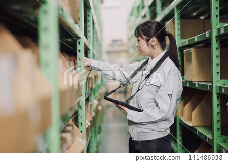 A woman who manages inventory in a warehouse A woman who manages inventory in a warehouse 141486938