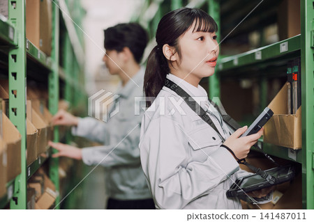 在倉庫工作的年輕男女 在倉庫工作的年輕男女 141487011