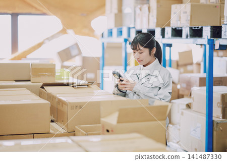 A woman who manages inventory in a warehouse A woman who manages inventory in a warehouse 141487330