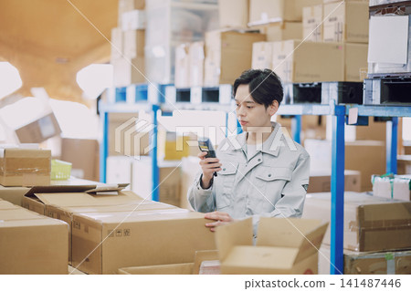 一名身穿工作服的男子正在清點庫存。 一名身穿工作服的男子正在清點庫存。 141487446