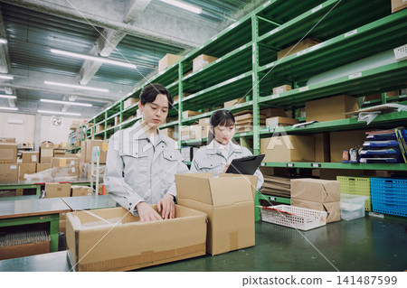 Young men and women working in a warehouse Young men and women working in a warehouse 141487599