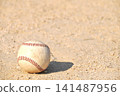 A baseball rolling on a dirt field 141487956