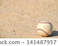 A baseball rolling on a dirt field 141487957