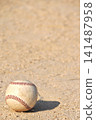 A baseball rolling on a dirt field 141487958