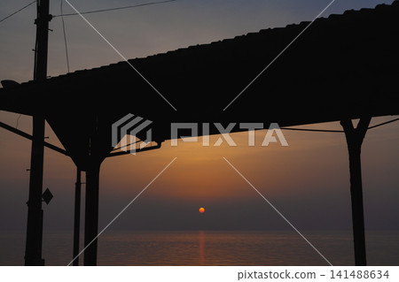The sunset and the sea as seen through the roof frame of the Shimonada Station platform. The sunset and the sea as seen through the roof frame of the Shimonada Station platform. 141488634