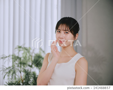 一位年輕女子感到皮膚濕潤 一位年輕女子感到皮膚濕潤 141488657